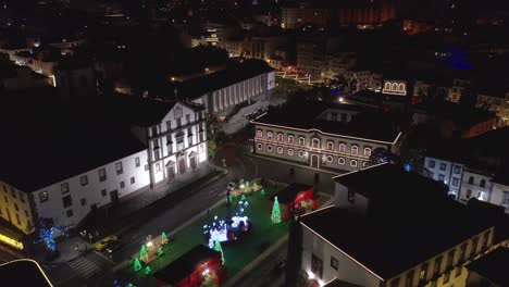 Christmas-time-in-Funchal-at-Praca-do-Município-square-with-famous-Church-of-Saint-John-the-Evangelist,-night,-aerial
