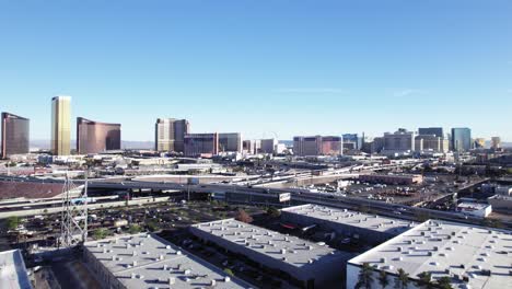 Rising-Aerial-View-of-Freeway-and-Las-Vegas-Casino-Strip-Skyline-with-Clear-Blue-Sky,-Establishing-Shot
