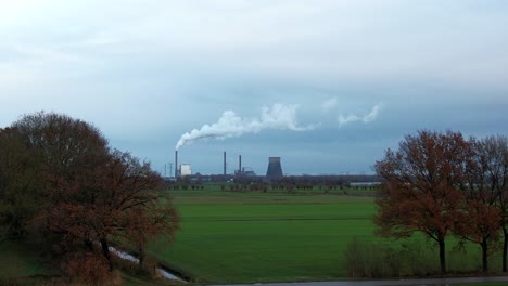 Power-plant-dramatically-appears-behind-the-trees:-dolly-shot-with-drone