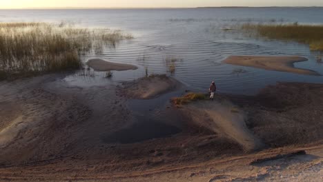Isolated-person-on-lakeshore-at-sunset,-Laguna-Negra-in-Uruguay