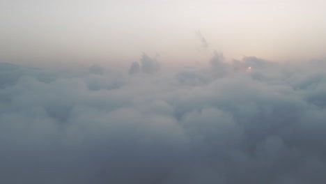 Aerial-drone-shot-of-beautiful-white-clouds-passing-by-during-sunset-over-the-sky-of-Golan-Heights,-Israel