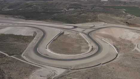 Single-bend-in-Almeria-race-track-in-Spain-surrounded-by-desert-and-olive-trees