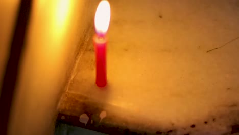 lighted-candle-flickering-in-dark-environment-from-flat-angle