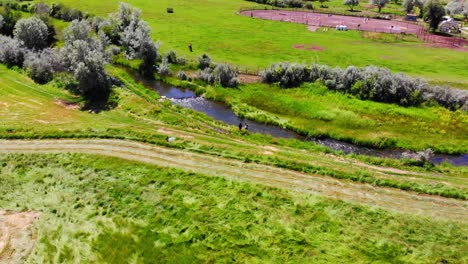 Two-People-Fishing-On-Flowing-River-Creek-In-Lush-Green-Colorado-Countryside