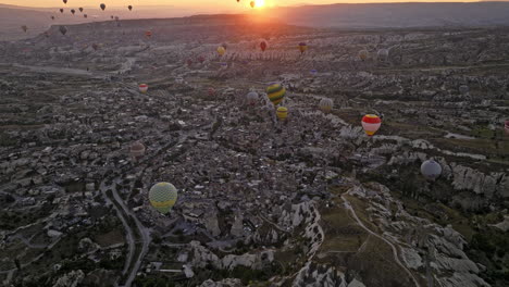 Göreme-Turkey-Aerial-V51-Vogelperspektive,-Die-Felsiges-Gelände-Und-Die-Alte-Dorfstadt-Von-Oben-Mit-Bunten-Heißluftballons-Hoch-Oben-Am-Himmel-Bei-Sonnenaufgang-Einfängt---Aufgenommen-Mit-Mavic-3-Cine---Juli-2022