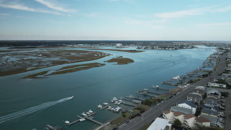 Wrightsville-beach-boats-driving-along-the-shoreline-wide-aerial-shot