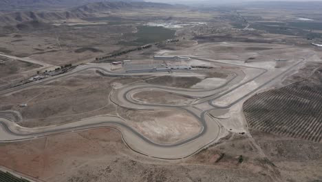 A-motor-sport-race-track-in-Europe-surrounded-by-mountains-and-a-dusty-desert