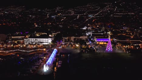 Night-time-at-Funchal-city-on-Madeira-Island-during-Christmas-holiday-with-light-decoration,-aerial