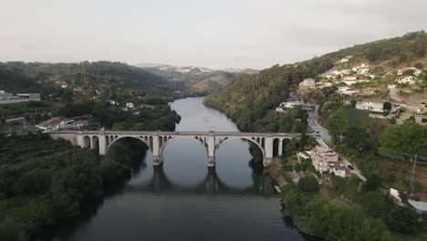 Dolly-Out-Shot-Der-Antiken-Historischen-Brücke-Mit-Bögen,-Die-Den-Fluss-Tamega-Bei-Entre-Os-Rios-Portugal-überqueren