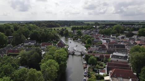 Aerial-view-of-drawbridge-on-river-Vecht-and-church-tower-in-Loenen,-Netherlands