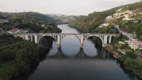 Panoramablick-Aus-Der-Luft-Umkreisende-Drohnenansicht-Der-Berühmten-Brücke-Ponte-De-Pedra-über-Den-Fluss-Douro-In-Der-Stadt-Entre-Os-Rios-In-Portugal