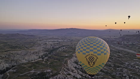 Göreme-Turkey-Aerial-v48-high-altitude-panoramic-view-flyover-ancient-village-capturing-surreal-sunrise-landscape-with-hot-air-balloon-and-rock-formations-terrain---Shot-with-Mavic-3-Cine---July-2022
