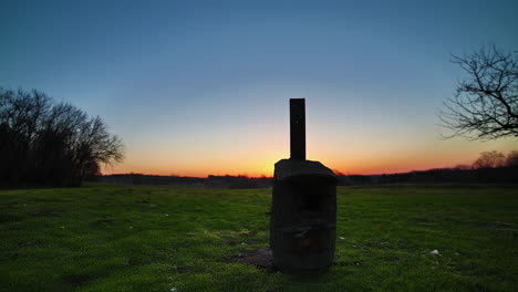 The-sunrise-breaks-from-behind-the-horizon-with-the-silhouette-of-a-birdhouse-in-the-foreground---motion-time-lapse