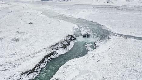 Beautiful-and-stunning-Godafoss-waterfall-in-tranquil-snowy-winter-scenery---Aerial-high-angle-rotate-shot