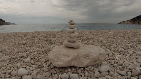 The-art-of-balancing-stones-on-a-rocky-beach-in-Cephalonia,-Greece