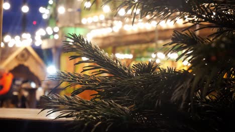 Weihnachtsbaum-Kiefernnadeln-Nahaufnahme-Flacher-Dof-Beleuchteter-Weihnachtsmarkt-Nacht-Party-Dolly-Links