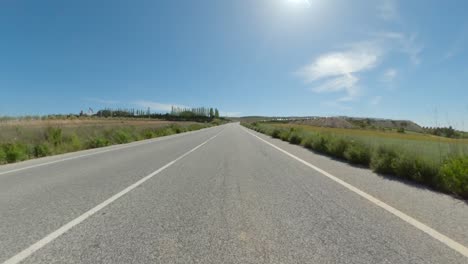 POV-motorcycle-ride-along-clear-roads-with-cloudless-blue-skies-on-a-sunny-day