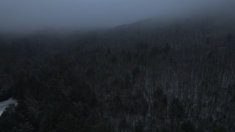 Aerial-drone-video-footage-of-a-beautiful-snowy,-foggy-evening-with-low-clouds-in-the-Appalachian-mountains-during-winter