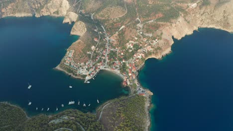 Top-down-view-Assos-fishing-village-and-hilltop-castel,-Kefalonia-Island-Scenery