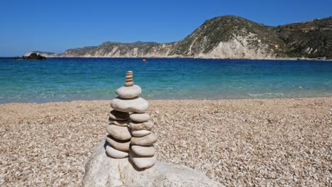Stack-of-pebbles,-Rock-balancing,-stone-stacks-on-the-beach-of-Agia-Eleni-in-Greece---wide,-static