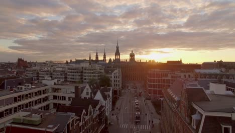 An-Aerial-Flyover-of-the-busy-streets-of-Amsterdam,-Italy-at-Sunrise