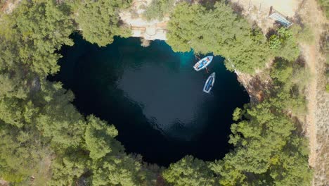 Beautiful-aerial-view-touristic-boats-on-famous-Melissani-cave,-Kefalonia-Island