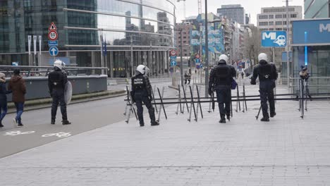 Unrecognizable-riot-police-in-full-riot-gear-cordon-off-a-street-to-protect-the-European-district-in-Brussels,-Belgium