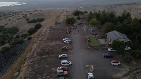 Aerial-drone-view-over-cars-and-people,-at-a-viewpoint-in-the-Golan-Heights,-dusk-in-Israel