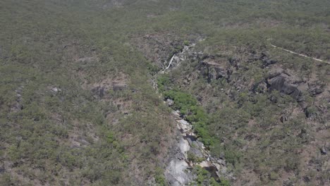 A-Waterfall-In-The-Middle-Of-Rainforest-At-Davies-Creek-In-Queensland,-Australia---aerial-drone-shot