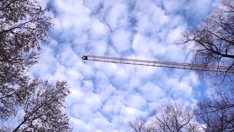 Construction-crane-panning-slowly-across-beautiful-blue-sky