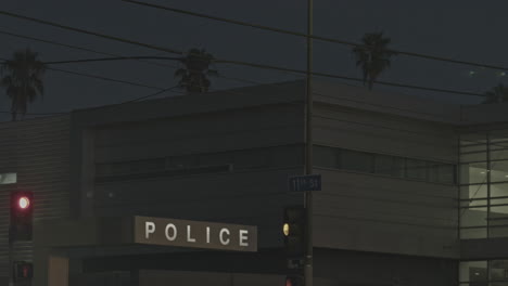 Traffic-lights-and-police-station-at-night-with-palm-trees-as-background
