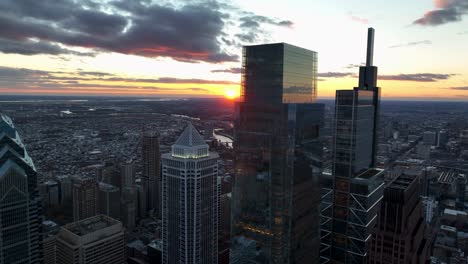Aerial-turn-of-urban-city-skyline-at-dusk-sunset