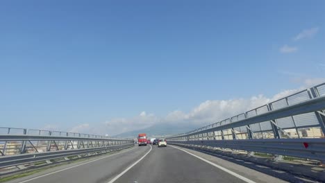 Driving-on-a-narrow-and-busy-highway-with-extended-guard-rails-high-above-the-city-in-Europe