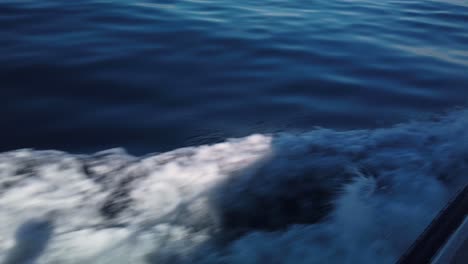 Gimbal-close-up-shot-of-the-fast-flowing-undertow-wake-from-a-small-charter-boat-moving-on-the-ocean