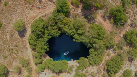 Aerial-top-down-view-Boat-crossing-lake-in-Melissani-Cave,-Beautiful-Scenery