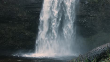 Kaskadierender-Wasserfall-Mit-Spray-Und-Gehacktem-Baumstamm-In-Wales-Uk-4k