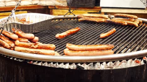 German-sausage-cooking-on-hot-griddle-at-city-winter-food-market-stall