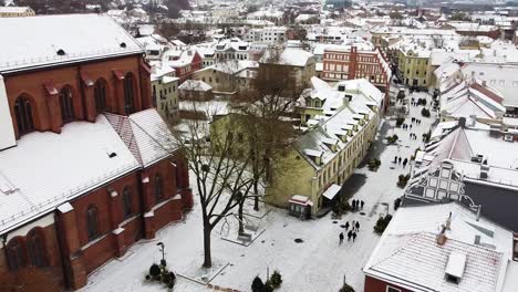 Kaunas-Cathedral-Basilica-and-old-town-buiildings-covered-with-snow,-aerial-view