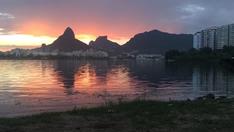 Sonnenuntergang-Am-Stadtsee-In-Rio-De-Janeiro-Kulisse-Hinter-Den-Beiden-Brüdern-Und-Einem-Berg-Mit-Ihrem-Spiegelbild-Im-Wasser-Im-Vordergrund