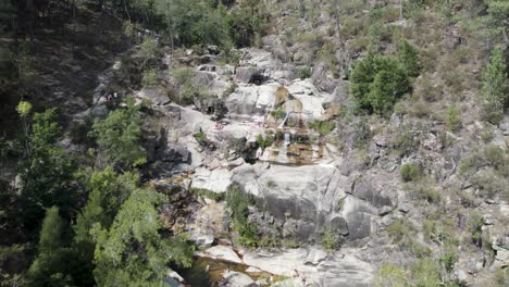 Visitors-at-Fecha-de-Barjas-waterfall,-Peneda-Gerês-National-Park