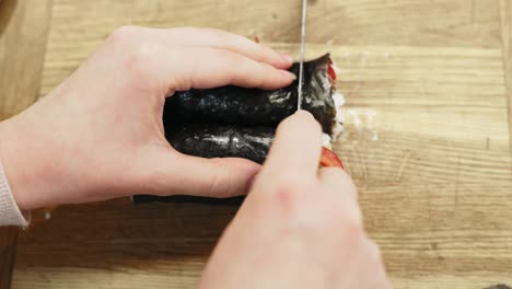 Cutting-homemade-sushi-rolls,-top-down-view