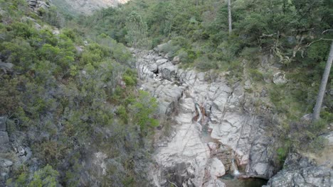 Aerial-slowly-pullback-reveal-Idyllic-scenery,-river-stream-cascade,-Gerês---Portugal