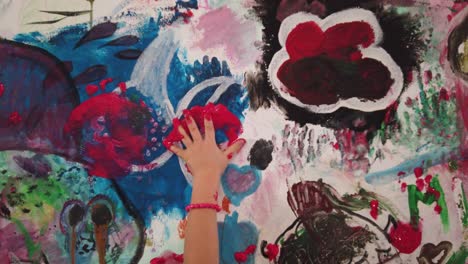 Kind-Im-Rosa-Tanzkleid-Handmalerei-Mit-Roten-Händen-Eine-Bunte-Wand