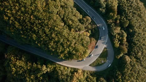 Kurvenreiche-Straße-Durch-Einen-Herbstwald,-Autos,-Die-Eine-Scharfe-Kurve-Nehmen