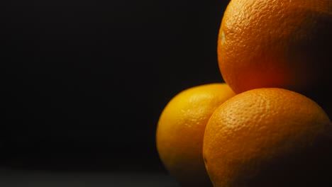 Statische-Aufnahme-Von-Orangenfrüchten,-Schwarzer-Hintergrund,-Textplatzhalter