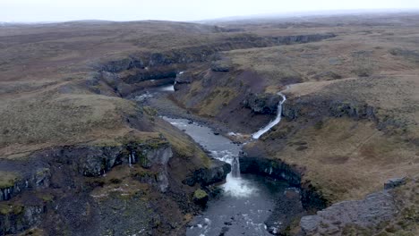 Aerial-shot-of-Three-waterfalls-in-remote-Selá-river-canyon-in-North-Iceland-during-autumn---Aerial-revealing-shot