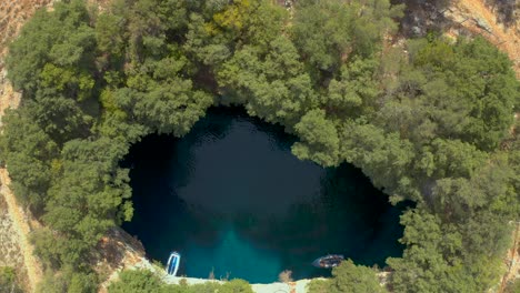 Top-down-view-descending-towards-Scenic-Melissani-cave,-Kefalonia-island
