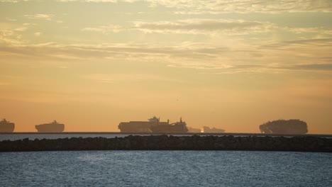 Many-cargo-ships-docked-and-waiting-to-be-unloaded-during-a-global-supply-chain-crisis-at-sunset