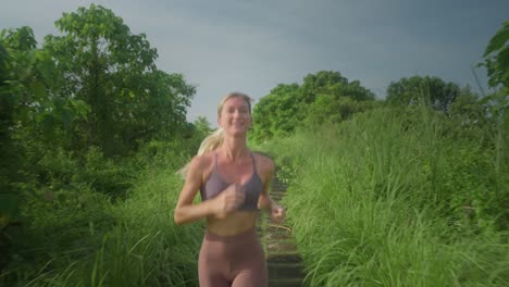 Fitte-Athletische-Frau,-Die-Beim-Laufen-Auf-Campuhan-Ridge-In-Bali-Lächelt,-Blonde-Frau-Mit-Tollem-Körper