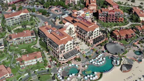 Aerial-view-orbiting-luxury-Cabo-holiday-resort,-over-Sheraton-tilt-up-to-ocean-horizon-view